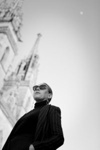 Woman in black in front of blurred cathedral in Basel